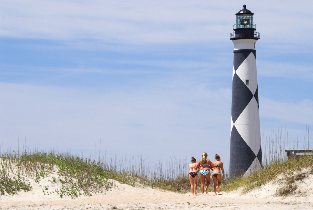 Three girls walking t a lighthouse in Outer Banks 