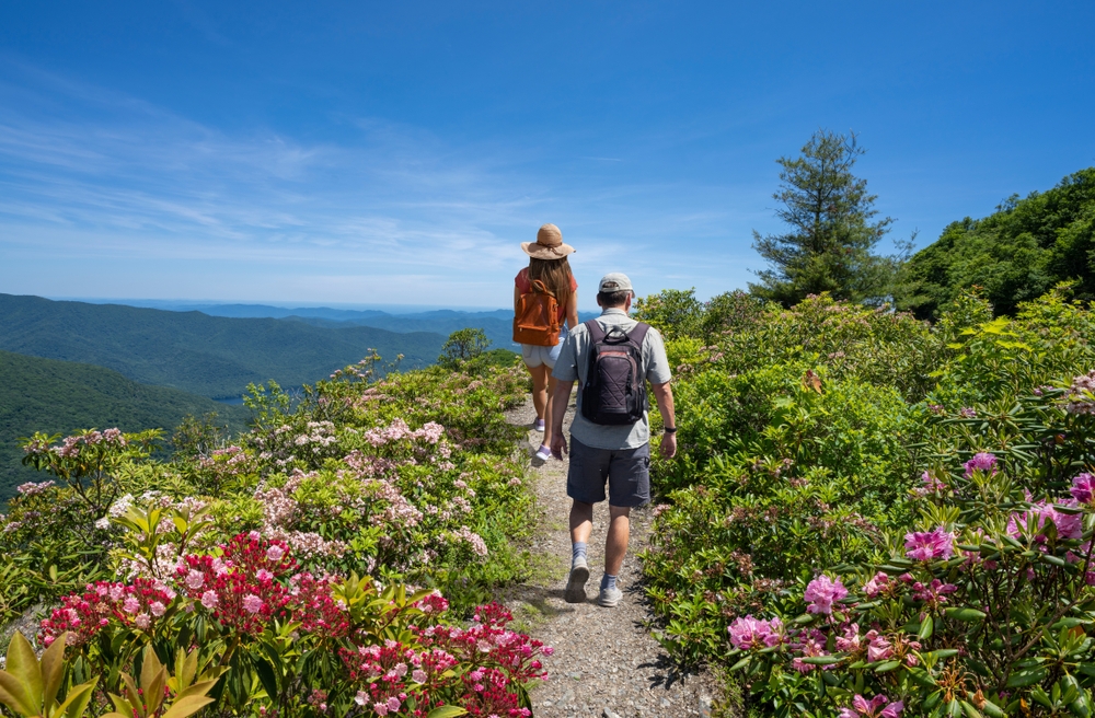 Couple hiking on summer vacation trip. Friends hiking in the mountains. Milepost. Near Asheville, Blue Ridge Mountains, North Carolina