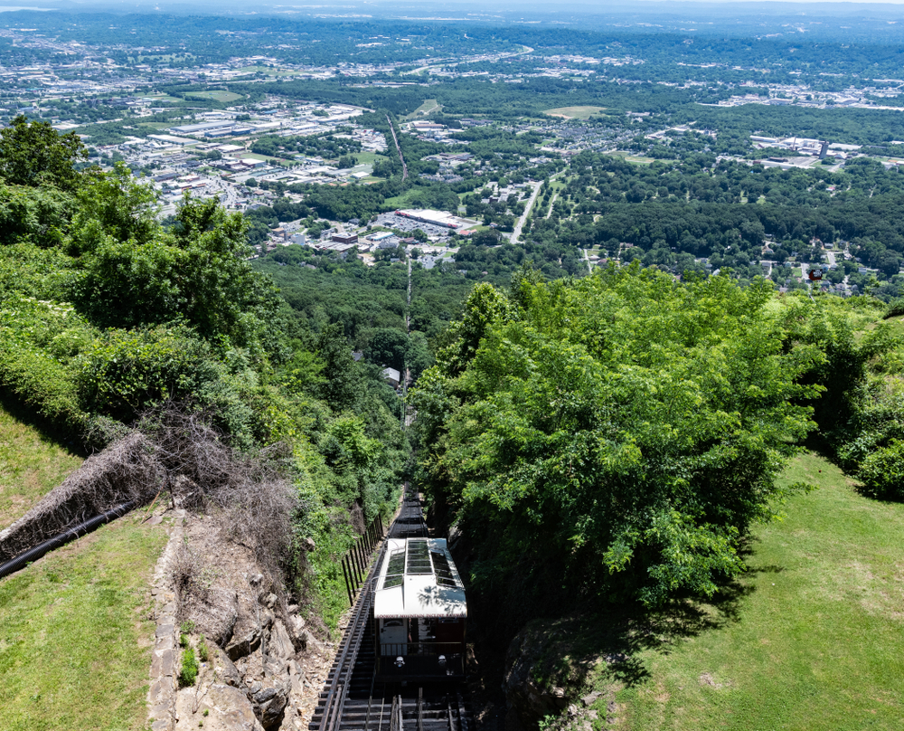 the lookout mountain incline railway with a train running down the tracks. 