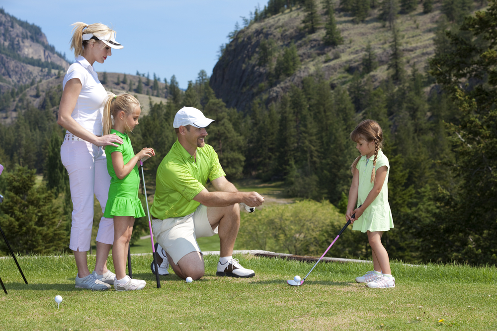 a family golfing in at the stone mountain club with beautiful mountains in the back ground 