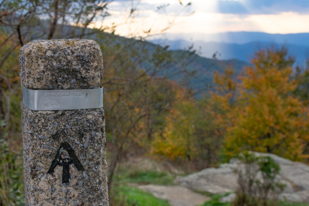 the view of the Appalachian trail marker made of concrete pointing which way to keep going on the trail. this is one of the best hikes in the Shenandoah national park 