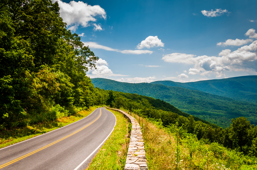 a lovely drive from the skyline drive. this is one of the best things to do in Harrisonburg VA. you can see the blue mountains in the back round and the pretty green trees on the other side of the road 