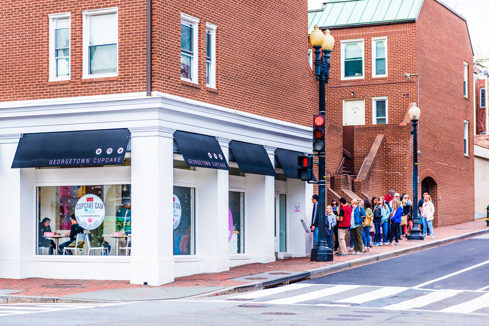 Exterior of the Georgetown Cupcake store with people lined up out the door.