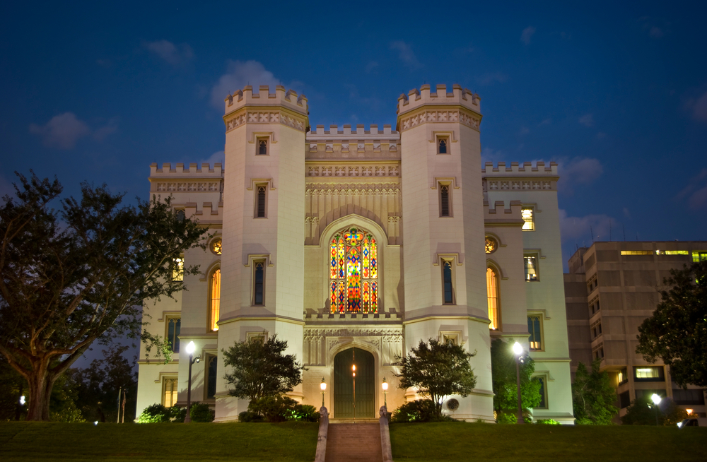 The Old State Capitol building in Baton Rogue, lit up at night with a stained glass window in the center. 