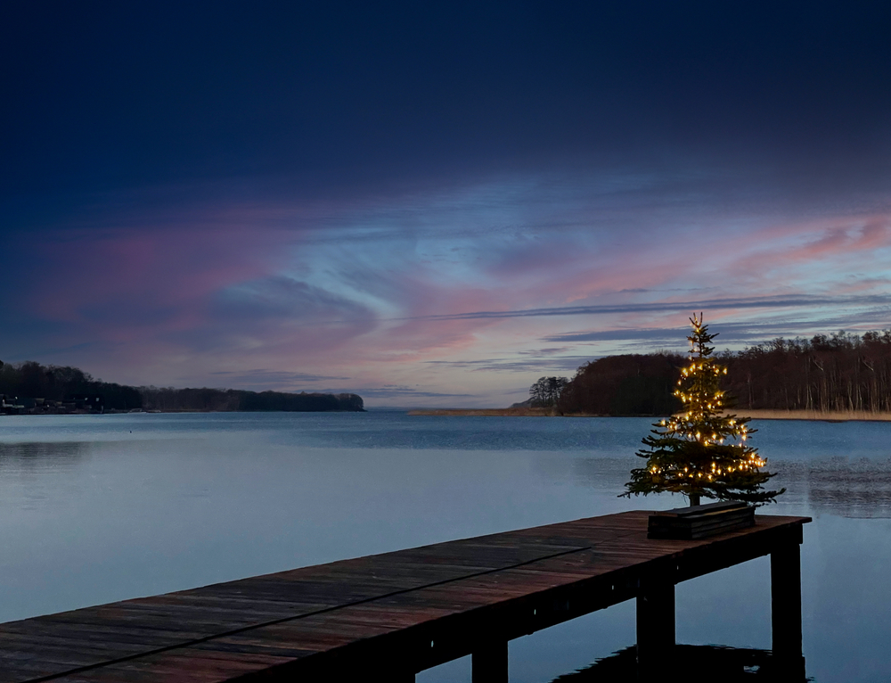 a christmas tree at the end of a pier on a cold lake in Boone nc. this is great place to see christmas lights and enjoy a walk around the lake 