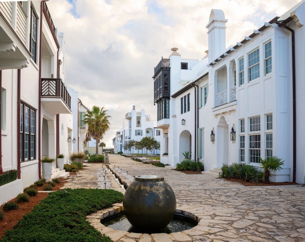 places in the South USA that look like Europe, alys beach with white buildings and cobblestone walking paths, palm tree near a building on the left 