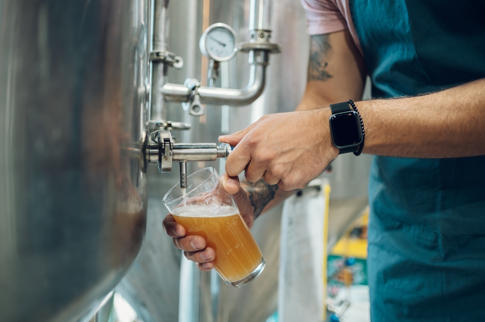 brewery in Boone North Carolina with a man pouring a beer and wearing a smart watch 