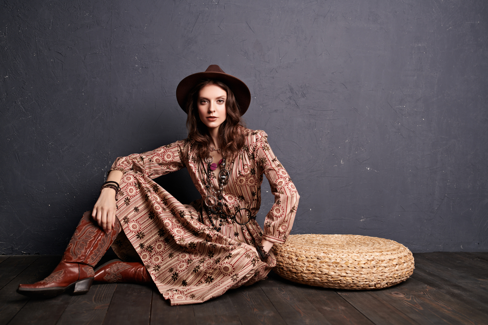 A girl in a dress a cowboy hat and boots in an article about what to wear in Nashville