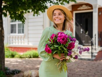 woman standing holding cute bouquet of flowers in a cute nashville outfit