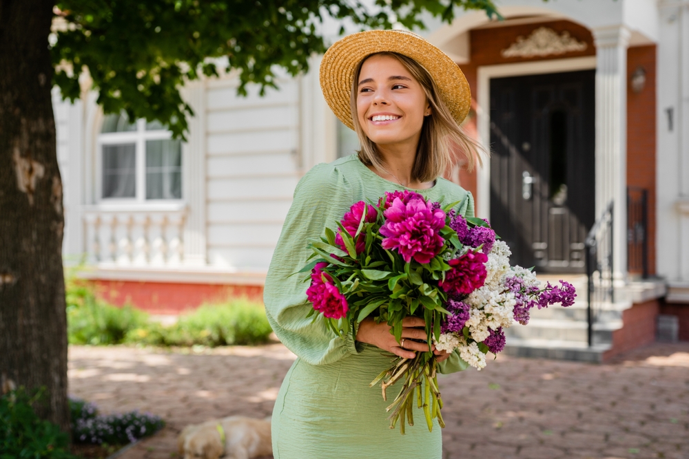 woman standing holding cute bouquet of flowers in a cute nashville outfit