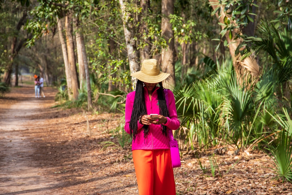 women walking down a street looking at her phone.  Savannah GA Outfit Ideas