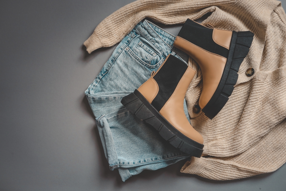 jeans and jumper with boots on a flatlay. 