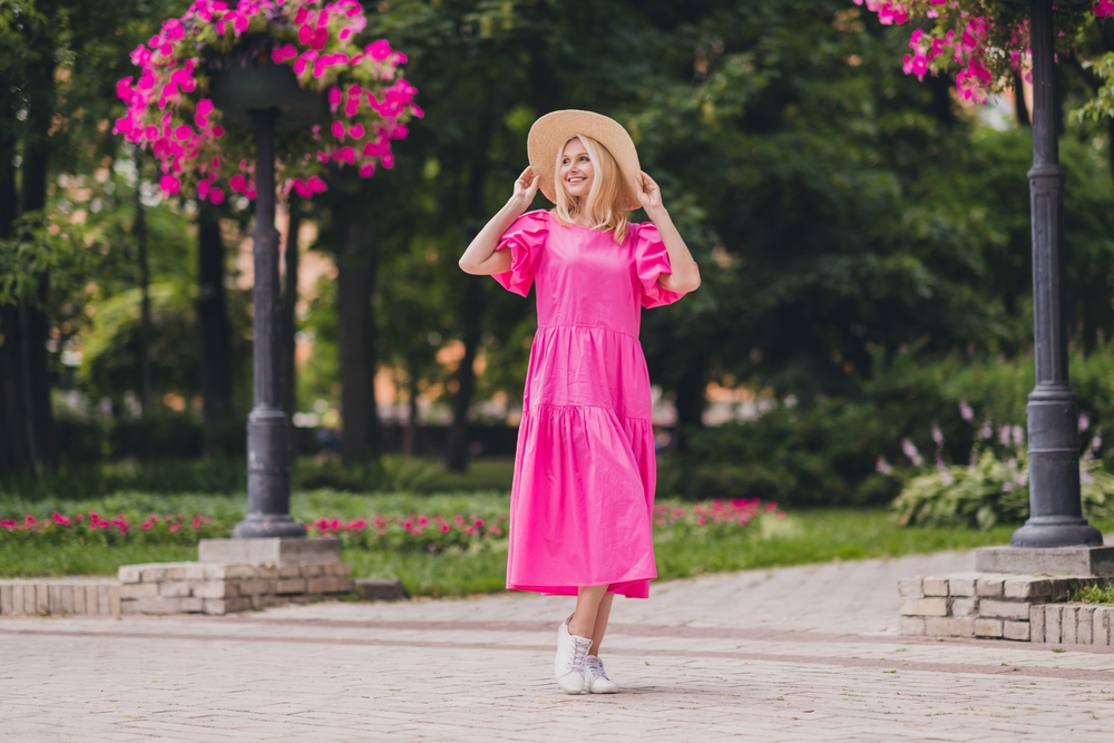 a woman in bright pink sundress with hat and white sneakers is perfect outfit to wear for spring in DC