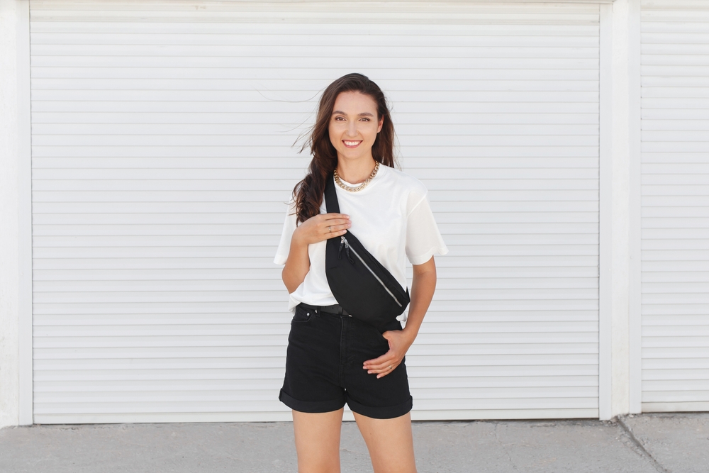 a girl in white teeshirt, black shorts and crossbody back for a spring in DC outfit