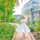 a girl in white dress walking in botanical garden