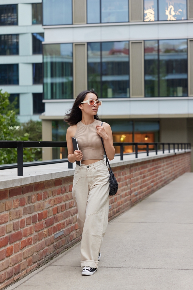 a woman in wide leg jeans and crop top walking down the road is perfect if looking what to wear in Washington Dc in Summer