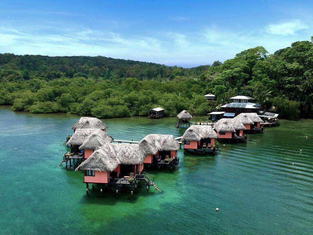 pink water bungalows with greenery in the background. 