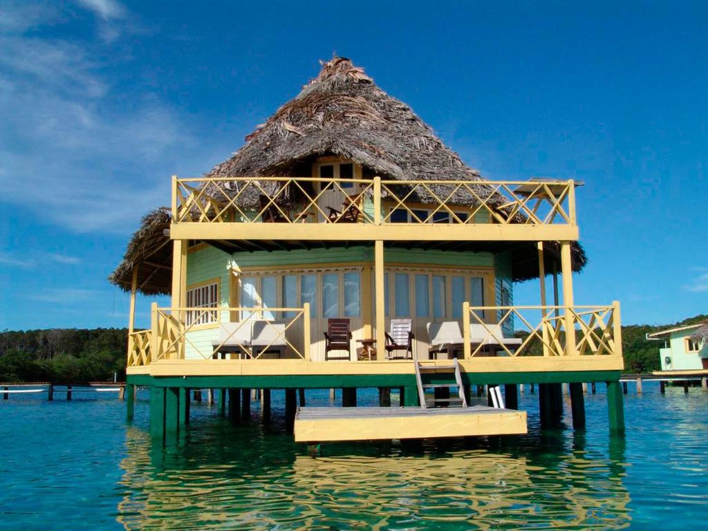 double story thatched overwater bungalow with a deck. 