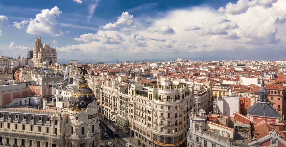 An overhead view of Madrid shows tall, stunning white buildings, with terra cotta roofs. 