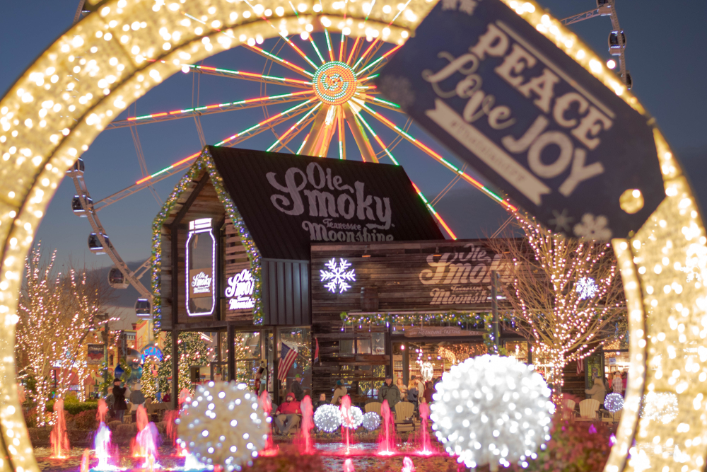 Christmas time at The Island at Dollywood in Pigeon Forge with the Ferris wheel lit up in the background behind the Ole Smoky Tennessee Moonshine store.