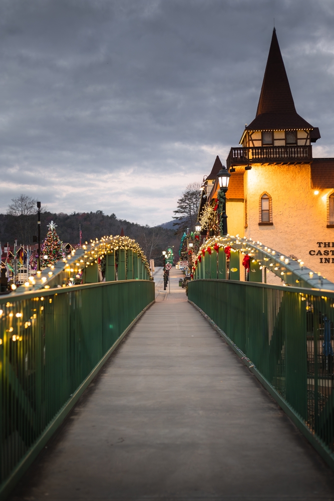 Photo of bridge and castle looking building with Christmas lights. 