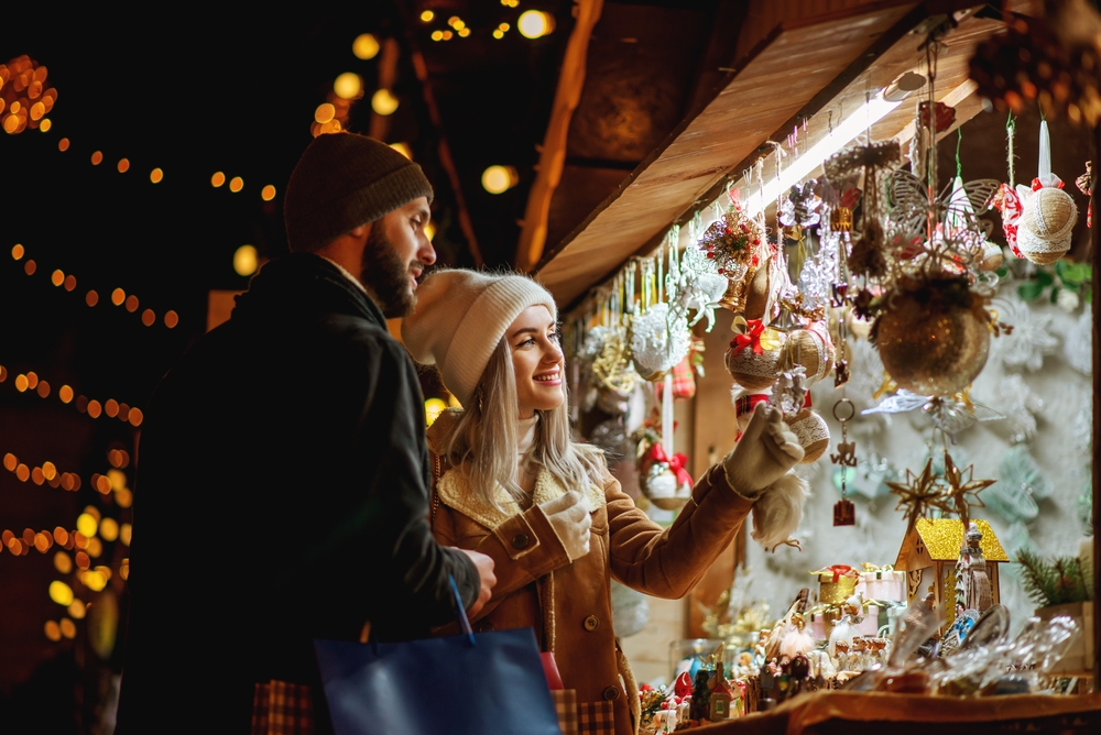 Happy smiling couple shopping at Christmas street market