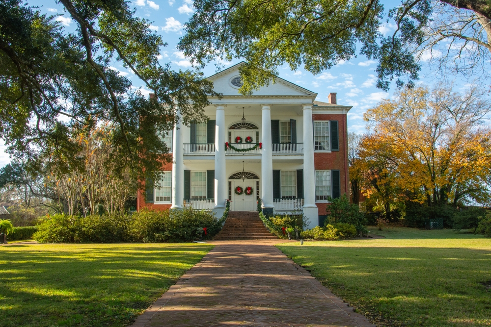 Grand Greek Revival style historic pre-Civil War Rosalie Mansion with built on the bluff overlooking the Mississippi River in Natchez.  The article is about Christmas in the South USA. 