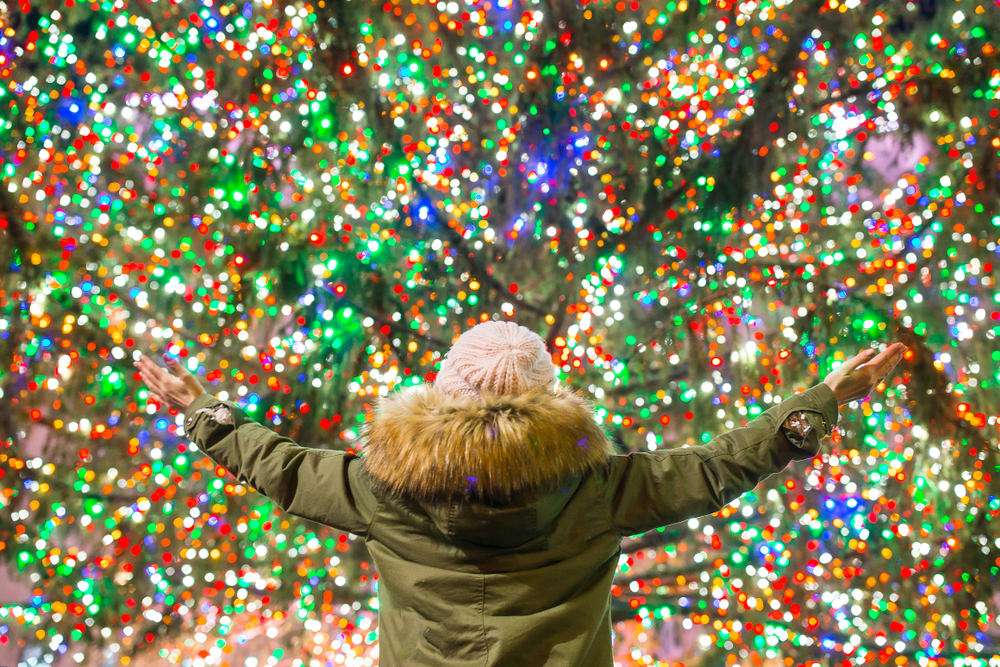 girls with arms stretched in front of Christmas lights. The article is about Christmas in the South USA. 