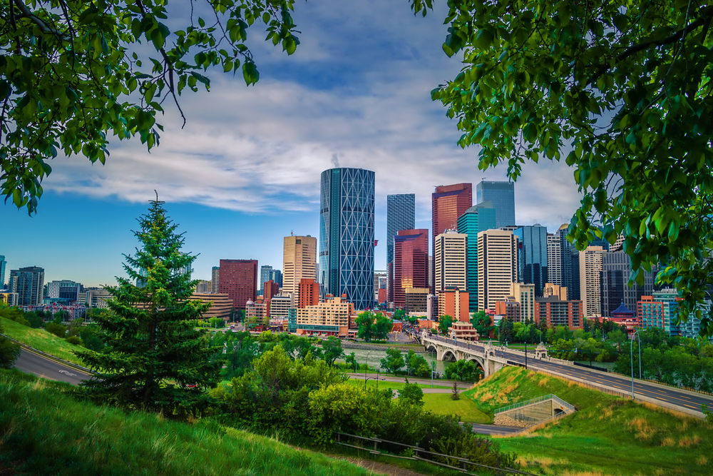 Downtown Calgary views from a summer park lookout. The article is about cheapest places to fly from Houston.