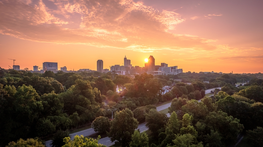 Downtown Raleigh, North Carolina at sunrise. The article is about cheapest places to fly from Houston.