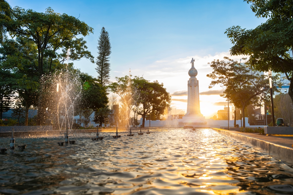 Square known as Salvador del mundo located in the capital of El Salvador with a statue in the center while sunrise
